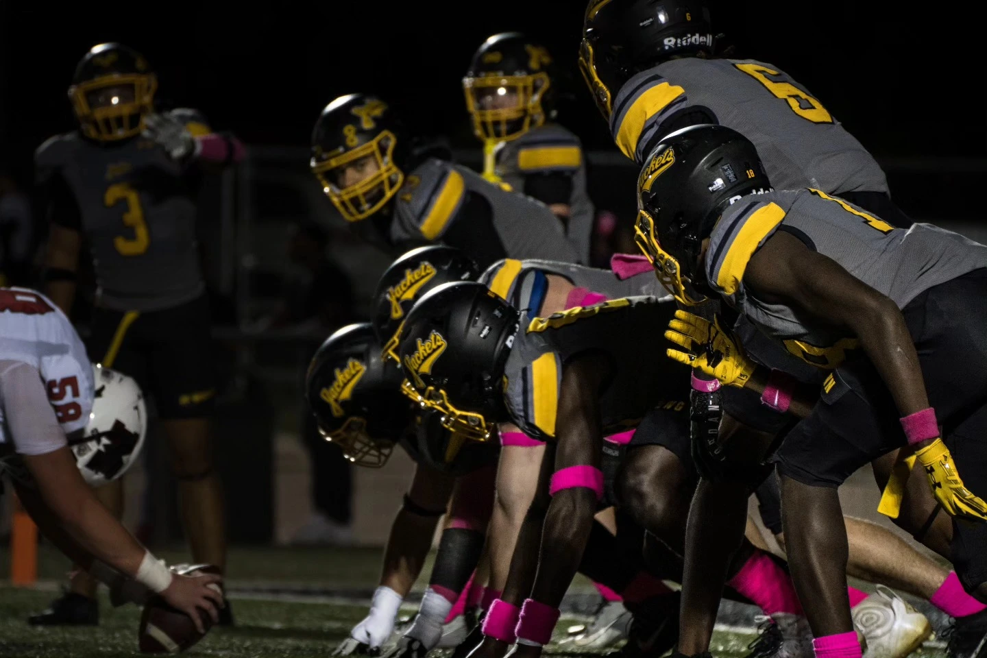 Football players in black and gold lined up before the snap